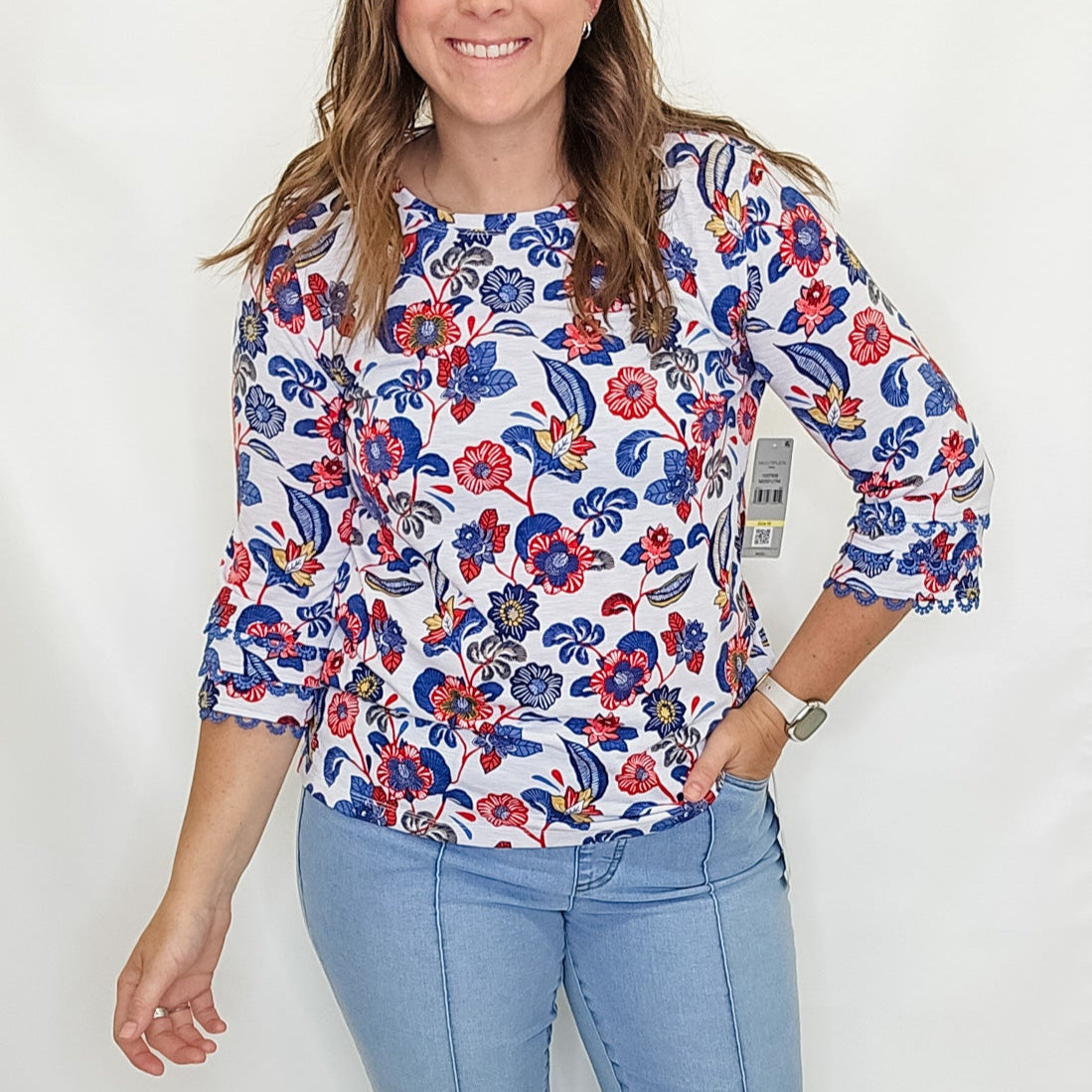 Woman wearing a floral blouse and blue jeans on a white background