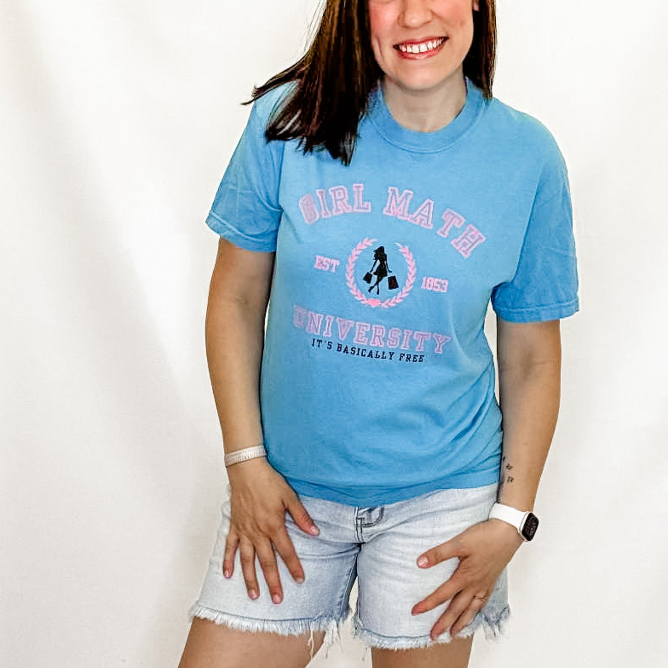 Person wearing a blue t-shirt with 'Girl Math University' text and graphic on a white background