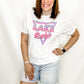 Person wearing a white t-shirt with 'LAKE Belie' design on a plain background