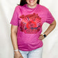 Person wearing a pink t-shirt with red graphics and text on a white background
