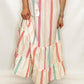 Woman wearing a pink top and colorful skirt on a white background